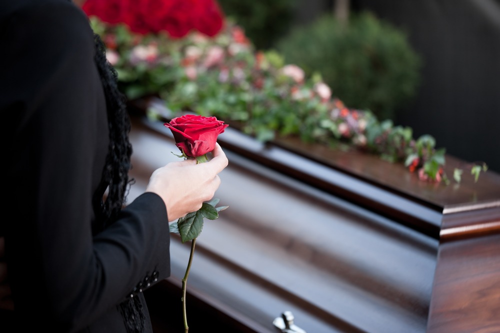 woman mourns over loved ones casket