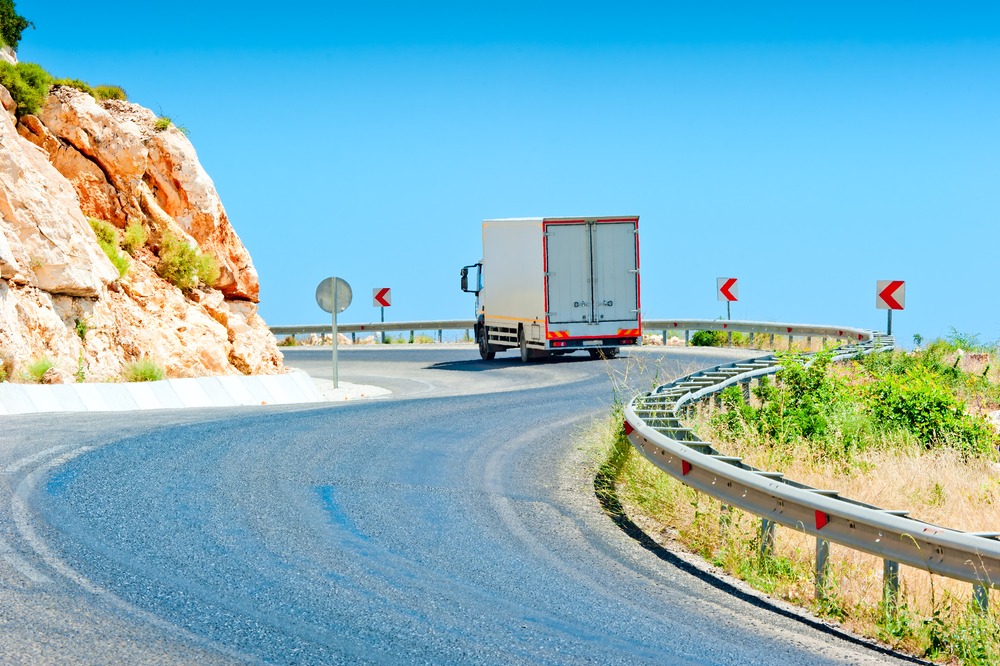 commercial truck moving up incline on tight curve