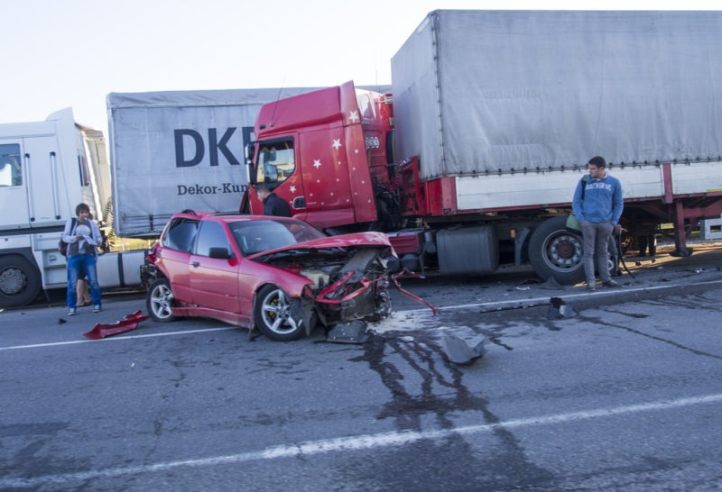 a totaled car after a collision with a large truck
