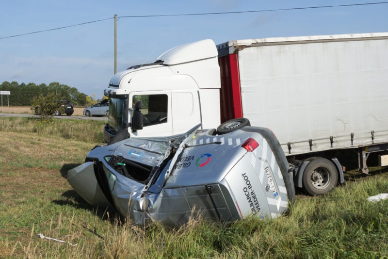 a van on its side after a collision with a large truck