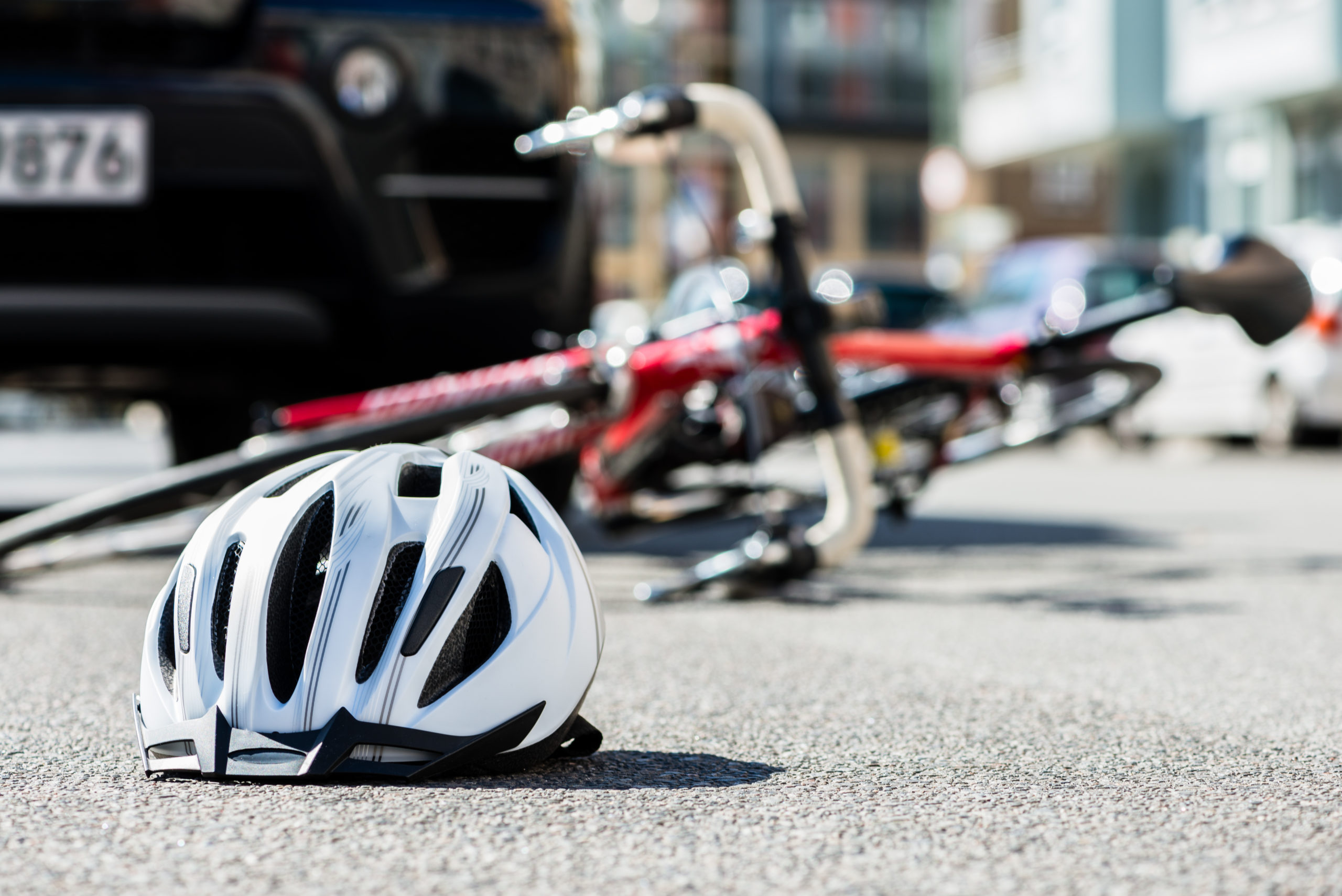 fallen-helmet-and-bicycle-in-middle-of-road-near-car