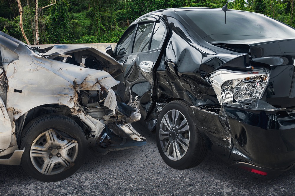 a silver car and a black car damaged in a crash