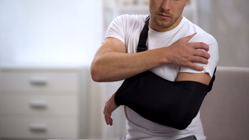man holds his shoulder after a slip and fall accident