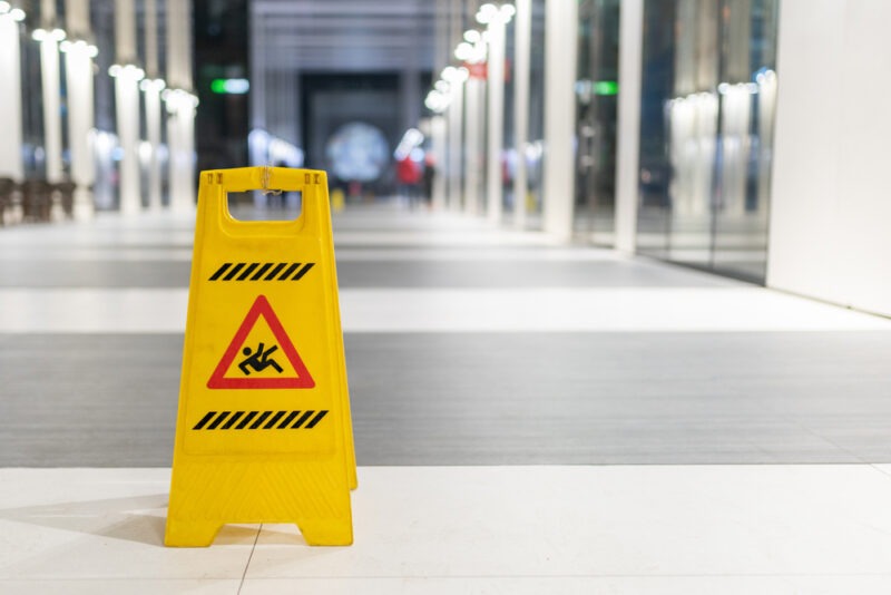 Yellow slippery floor sign on wet floor office.